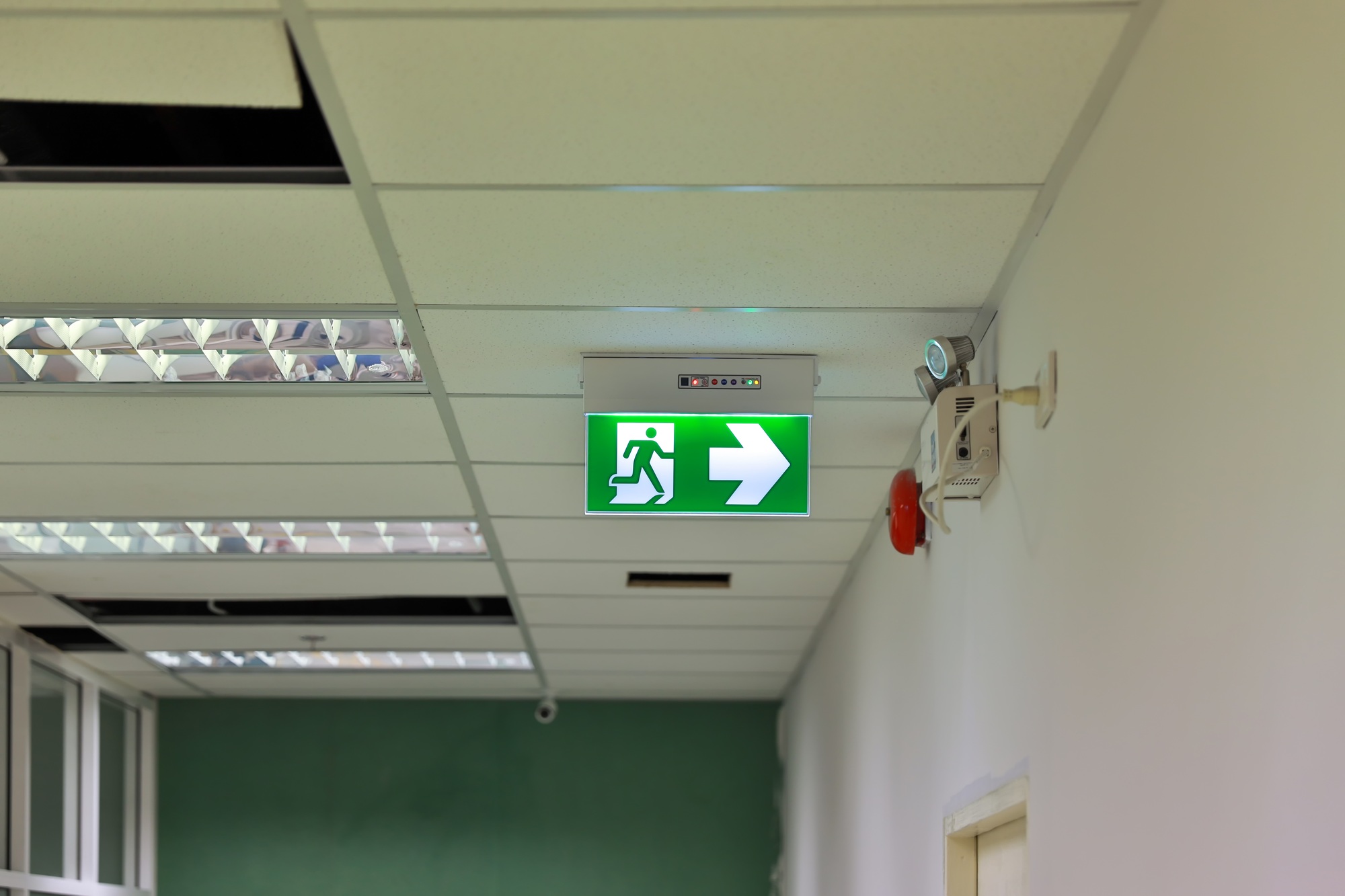 Green emergency exit sign showing the way to escape.